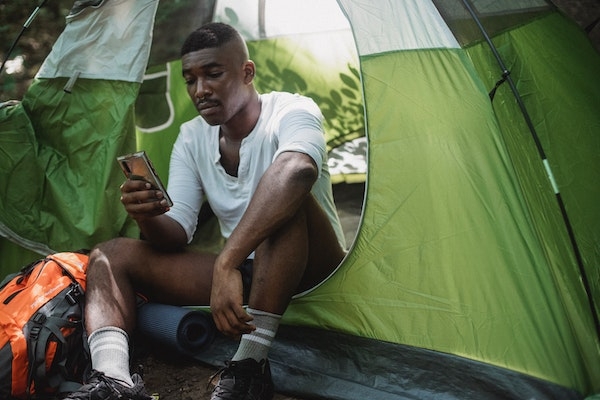 Homme regardant son smartphone dans une tante