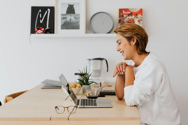 Femme qui sourit en face d'un ordinateur portable