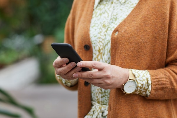 Téléphone dans les mains d'une personne âgée