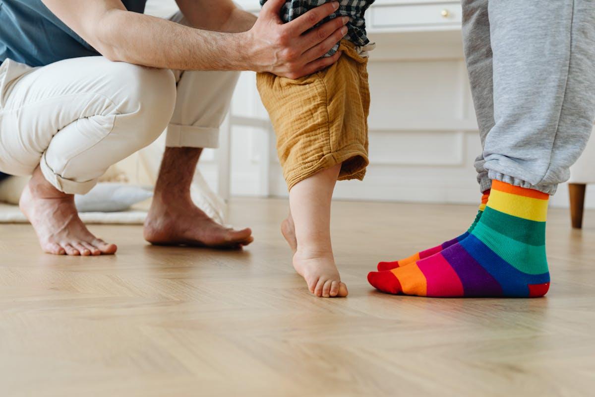 Papa aidant son bébé à faire ses premiers pas — souvenir à conserver dans une capsule temporelle