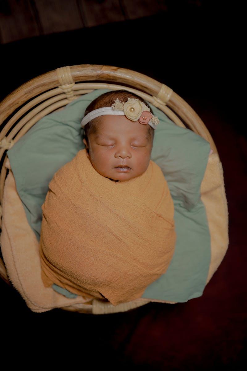 Nouveau-né endormi dans un panier lors d'une séance photo professionnelle — cadeau de naissance inoubliable