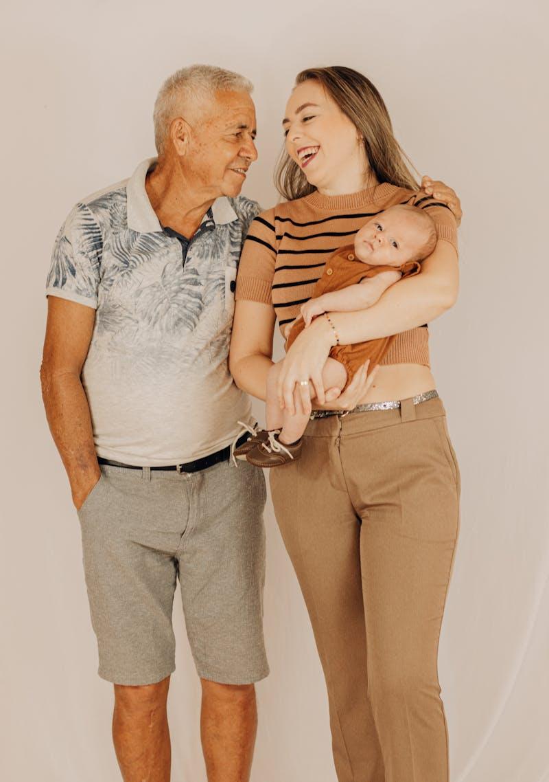 Grand-père, mère et bébé souriant — album photo familial partagé entre générations