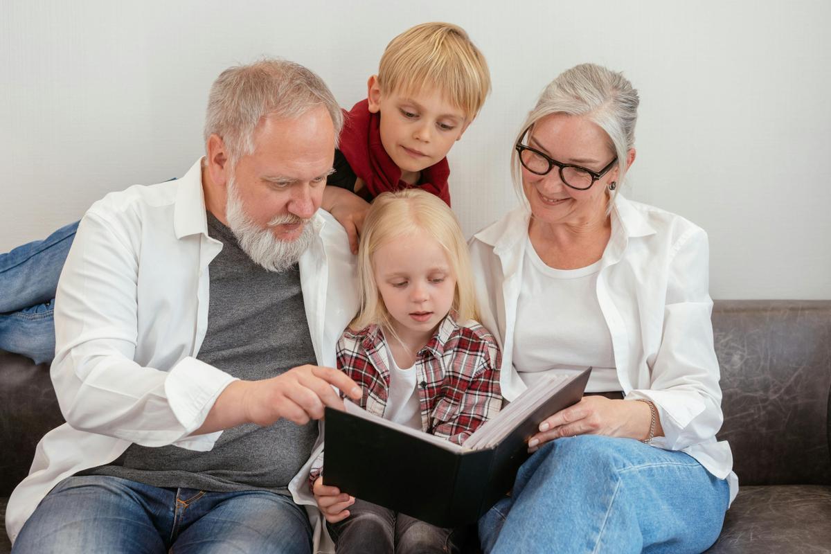 Des grands-parents et leurs petits-enfants regardent ensemble un album photo