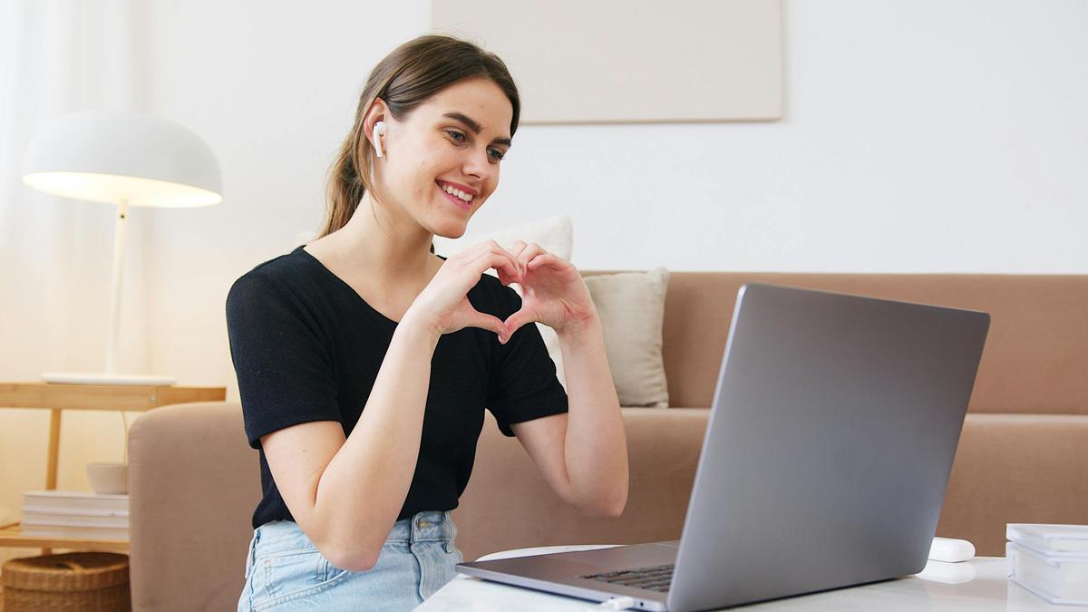 Femme souriante devant son PC