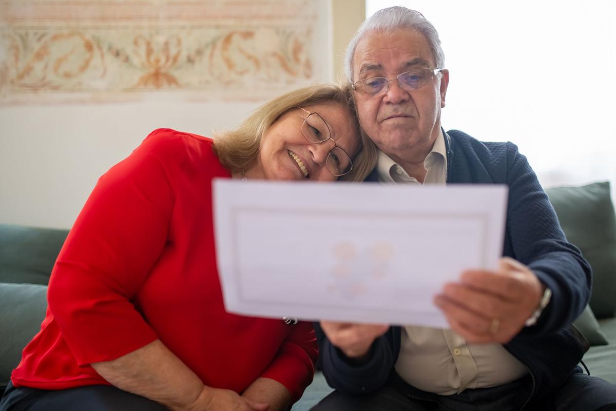 Grands-parents qui lisent ensemble le journal familial reçu par la Poste